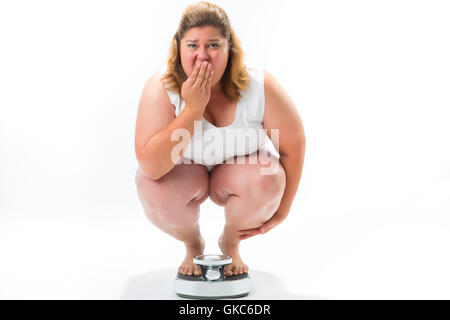 Spessore giovane donna accovacciata sulla scala Foto Stock