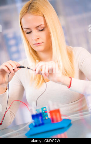 Donna scienziato con cella a combustibile idrogeno in laboratorio Foto Stock