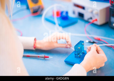 Donna scienziato con cella a combustibile idrogeno in laboratorio Foto Stock