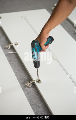 Montaggio di mobili nuovi con un cacciavite Foto Stock