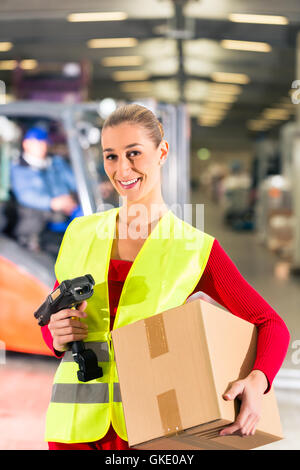 Lageristin di freight forwarding mantiene il pacchetto in un magazzino Foto Stock