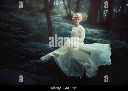 Ethereal woman dancing in dreamy foresta. Fantasia e surreale Foto Stock