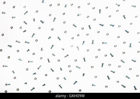 Molte viti in acciaio e i dadi su sfondo bianco Foto Stock