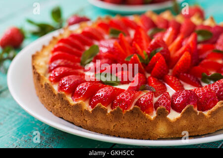 Crostata con fragole e panna decorato con foglie di menta. Foto Stock