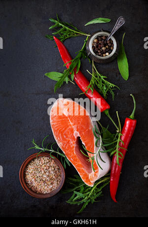 Materie bistecca di salmone e verdure per la cottura su uno sfondo nero. Menu dietetici. Una corretta alimentazione. Vista superiore Foto Stock