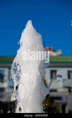 Fontana di pura acqua brillante contro un blu cielo chiaro Foto Stock