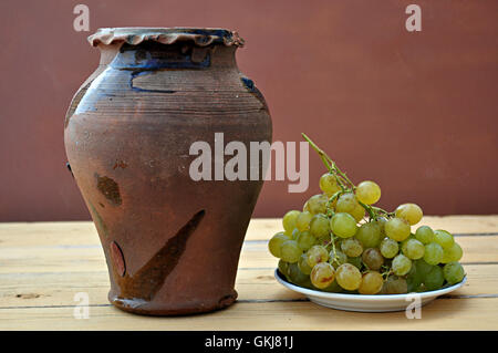 Argilla vaso antico e il mazzetto di uva Foto Stock