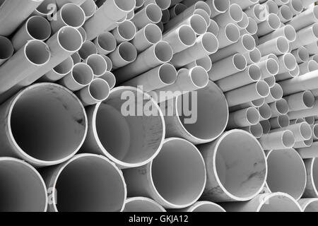 Tubi in PVC impilati in magazzino. Foto Stock