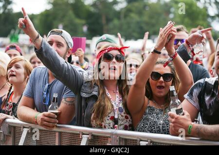 I frequentatori del festival guarda tutti i Santi eseguire sul supporto vergine stadio durante il V Festival a Hylands Park a Chelmsford Essex. Foto Stock