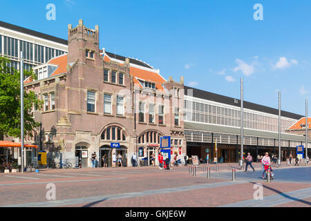 La gente e la stazione edificio sulla Stationsplein Square nella città di Haarlem, Olanda, Paesi Bassi Foto Stock