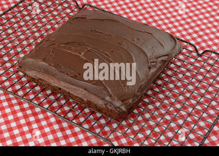 Torta al cioccolato con uno strato di glassa di cioccolato su un raffreddamento per rack Foto Stock