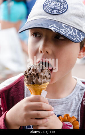 Un giovane ragazzo gode di un gelato al cioccolato. Foto Stock