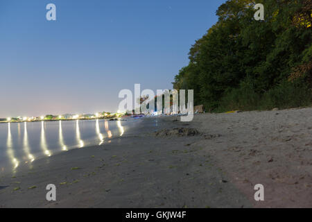 Spiaggia di notte ripiegato con ombrelloni e lettini Foto Stock