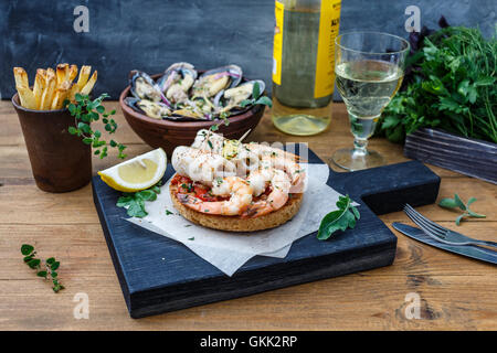 Bruschetta con gamberi sulla cucina rustica scheda. Foto Stock