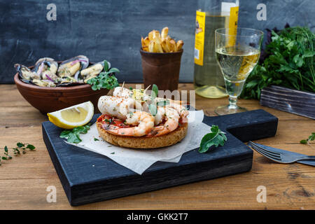 Bruschetta con gamberi sulla cucina rustica scheda. Foto Stock