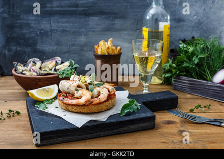 Bruschetta con gamberi sulla cucina rustica scheda. Foto Stock