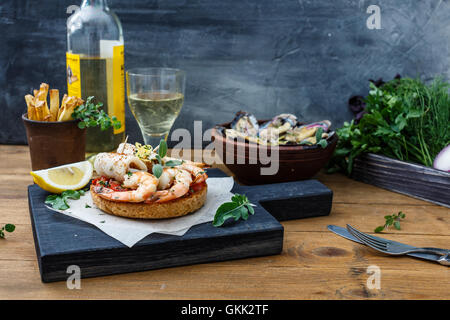 Bruschetta con gamberi sulla cucina rustica scheda. Foto Stock