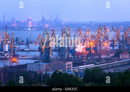 Porto commerciale di notte contro l'utilizzo impianto siderurgico in Mariupol, Ucraina. Paesaggio industriale. Merci nave Foto Stock