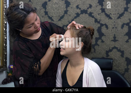 Donne sottoposte a trattamento per sopracciglia per addensare e modellamento in un salone di bellezza England Regno Unito Foto Stock