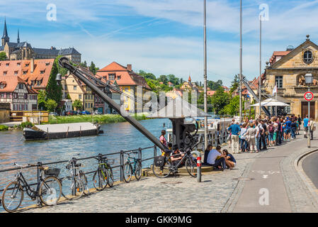 Vecchio derrick, le persone e le gite in barca al fiume Regnitz a Bamberg, Alta Franconia, Baviera, Germania Foto Stock