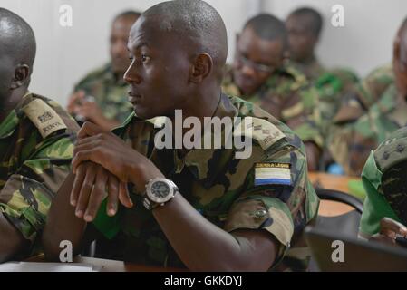 Un Sierra Leoneian CIMIC officer ascolta Lt. Alice Nabafu dal settore uno fare la sua presentazione durante il primo militare AMISOM eseguire Workshop CIMIC il cui scopo era quello di informare il settore CIMIC ufficiali dei loro ruoli e responsabilità che è quindi essenziale a sostegno del popolo somalo. Il workshop si è tenuto il 20 maggio 2014 a Mogadiscio. AU ISTPHOTO ONU/David Mutua Foto Stock