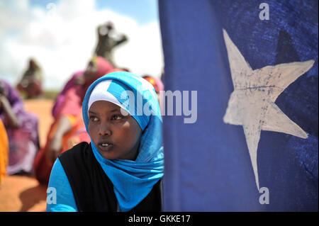 Una giovane donna tiene la bandiera somala durante una dimostrazione di una milizia locale, formato per fornire sicurezza in Marka, Somalia, il 30 aprile. AU ONU IST foto / Tobin Jone Foto Stock
