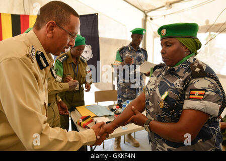 Somali commissario di polizia, Gen. Abdihakim Saacid, scuote la mano di Ispettore Rose Byaala dopo di lei una medaglia durante una medaglia cerimonia di premiazione per l Uganda formato unità di polizia di polizia il 9 luglio 2014 a Mogadiscio Stadium. Le medaglie sono stati aggiudicati a 138 agenti di polizia, uomini e donne che si avvicina al completamento della loro distribuzione per la Somalia. AMISOM foto / David Mutua Foto Stock