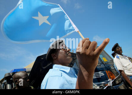 SOMALIA, Mogadiscio: In una fotografia messi a disposizione dall'African Union-United Nazioni Informazioni sul team di supporto 7 può essere un ufficiale con le forze di polizia somale (SPF) trattiene il paese della bandiera nazionale davanti a una cerimonia di consegna delle attrezzature donate dal governo del Giappone attraverso le Nazioni Unite ufficio politico per la Somalia (UNPOS) Trust Fund per sostenere la ricostruzione del SPF nella capitale somala Mogadiscio. Le attrezzature incluse un trasporto a motore flotta di 15 pick-up, due il personale di truppa porta e due ambulanze, 1.800 caschi balistici e set di manette, oltre mille VHF Foto Stock