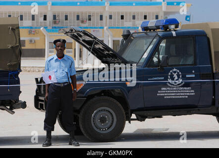 SOMALIA, Mogadiscio: In una fotografia messi a disposizione dall'African Union-United Nazioni Informazioni sul team di supporto 7 può essere un ufficiale con le forze di polizia somale (SPF) sorge su parata con la bandiera giapponese davanti a una cerimonia di consegna delle attrezzature donate dal governo del Giappone attraverso le Nazioni Unite ufficio politico per la Somalia (UNPOS) Trust Fund per sostenere la ricostruzione del SPF nella capitale somala Mogadiscio. Le attrezzature incluse un trasporto a motore flotta di 15 pick-up, due il personale di truppa porta e due ambulanze, 1.800 caschi balistici e set di manette, oltre 1,00 Foto Stock