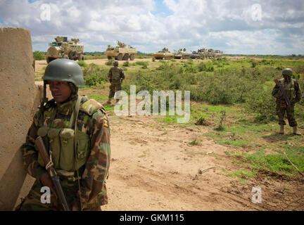 SOMALIA, Afgoye: In una fotografia datata 26 maggio e rilasciato dall'African Union-United Nazioni Informazioni sul team di supporto 27 Maggio, soldati ugandesi che serve con la missione dell Unione Africana in Somalia (AMISOM) sono visibili accanto a un convoglio lungo la strada che conduce a sud dalla città di Afgoye ad ovest della capitale somala Mogadiscio. Un joint-AMISOM e Somali Esercito Nazionale (SNA) offensiva ha guidato la Al Qaeda affiliate del gruppo estremista al Shabaab dall'area strategicamente molto importante del Corridoio di Afgoye, che il gruppo ha utilizzato come base per lanciare attacchi all'interno di Mogadiscio e è anche la casa di hundre Foto Stock