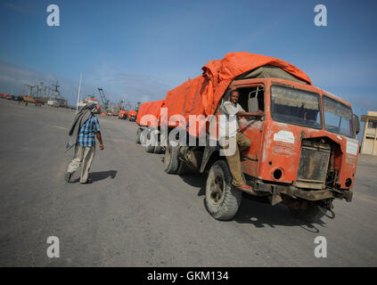 Un uomo corre a fianco di un camion al porto di Mogadiscio, in Somalia, il 6 agosto 2012. Ciò ha segnato il primo anniversario del ritiro di al Shabaab da posizioni fisse nella capitale, a seguito di perdite significative per il governo federale di transizione (TFG) e le truppe dell’AMISOM. Il ritiro pose fine alla presa di al Shabaab su Mogadiscio. Foto di AU-un IST. Foto Stock