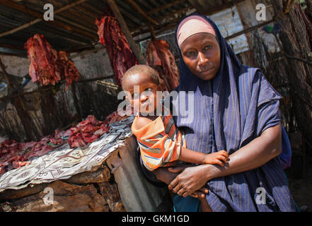 SOMALIA, Kismayo, in una fotografia scattata e rilasciato dall'African Union-United Nazioni Informazioni sul team di supporto 07 ottobre, un somalo donna vendita di carni provenienti da un chiosco trattiene il suo bambino in una area di mercato nel centro della Somalia meridionale città portuale di Kismayo, circa 500km a sud della capitale Mogadiscio. AU-ONU IST foto / STUART PREZZO. Foto Stock