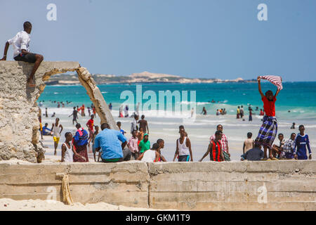 SOMALIA, Mogadiscio: In una foto scattata dal 09 novembre e rilasciato dall'African Union-United Nazioni Informazioni sul team di supporto 10 novembre, un ragazzo somalo detiene una maglietta aloft a secco nel vento alla spiaggia del Lido di Venezia in Abdul-Aziz distretto della capitale somala Mogadiscio. Spiaggia del Lido di Venezia è diventato un popolare luogo di venerdì con centinaia di somali dal ritiro in agosto 2011 di al Qaeda affiliate del gruppo estremista al Shabaab che aveva vietato qualsiasi di tali incontri sociali tra uomini e donne. Il Consiglio di Sicurezza delle Nazioni Unite il 7 novembre hanno rinnovato il mandato della missione dell Unione Africana in Somalia Foto Stock