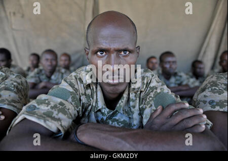 Un soldato somalo dell'esercito nazionale siede sotto copertura con i compagni di soldati in un campo di addestramento a Belet Weyne il 19 febbraio. La città, a 315 km da Mogadiscio, fu liberata da al-Shabaab nel 2011 e riconquistata dall'AMISOM nel 2012. Foto Stock