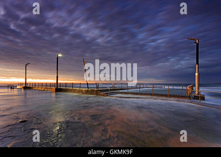 Piscina Piscina di roccia a Mona Vale Beach a Sydney isolati e tagliati fuori dalla Terra ad alta marea mediante il flusso di acqua di mare. Foto Stock