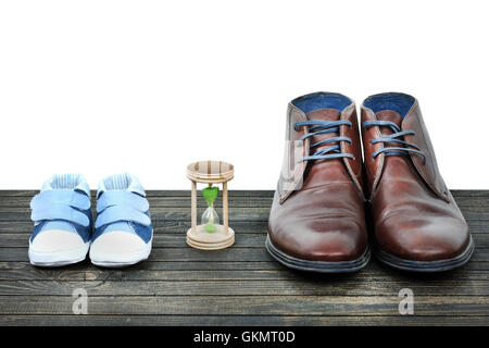 Crescere concetto con kid scarpe e calzature di business su pavimento in legno Foto Stock