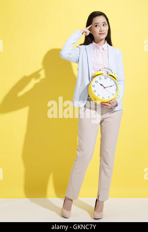 Giovane donna di affari in possesso di un orologio Foto Stock
