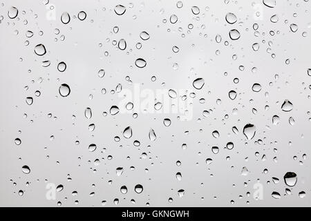 Foto di gocce di pioggia su un vetro polveroso. Foto Stock