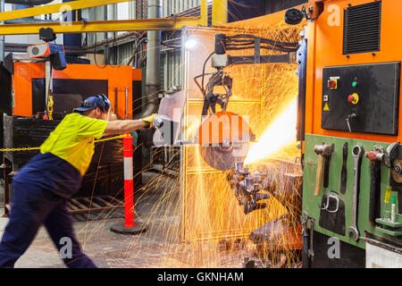 Operai in sicurezza di taglio usura, la rettifica di parti metalliche per ulteriore elaborazione la fabbricazione di componenti per il montaggio Foto Stock