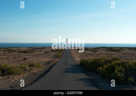 Isole Baleari, Spagna: la strada, macchia mediterranea e di Es Cap de Barbaria Faro, costruito nel 1972 all'estrema punta meridionale di Formentera Foto Stock