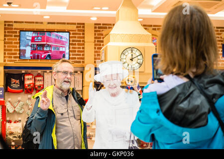 Divertente,royalty,i, Regina, saluta i turisti, a, turistiche, shop, uscita "glorioso Gran Bretagna' regali. Aerostazione partenze, l'aeroporto di Stansted, Londra,U.K. Foto Stock