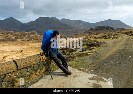 Un viandante sulla via da Kinloch a Harris baia con le montagne Coullin dietro, Isola di Rum, Ebridi Interne, Scotland, Regno Unito Foto Stock