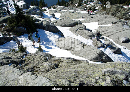 Più escursionisti invernali Monte Seymour, British Columbia scendendo dal primo picco innevato con il vertice di una valle di montagna Foto Stock