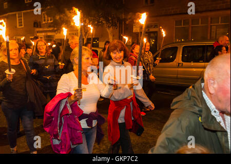 Bridport, Dorset, Regno Unito. 21 Ago, 2016. Circa 2 mila persone con torce fiammeggianti prendere parte all'annuale Bridport Carnevale Torchlight Parade che esce da Bucky Doo Square a Bridport Town Hall e va alla spiaggia di West Bay su un percorso di un miglio e mezzo. Credito Foto: Graham Hunt/Alamy Live News Foto Stock