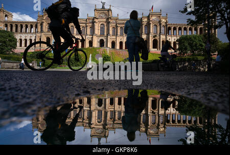 Monaco di Baviera, Germania. 21 Ago, 2016. Il Maximilianeum, quale casa bavarese del parlamento statale si è riflessa in una pozzanghera dopo una doccia a pioggia a Monaco di Baviera, Germania, il 21 agosto 2016. Foto: Peter Kneffel/dpa/Alamy Live News Foto Stock