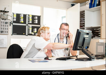 Gli infermieri presso il contatore sul telefono Foto Stock