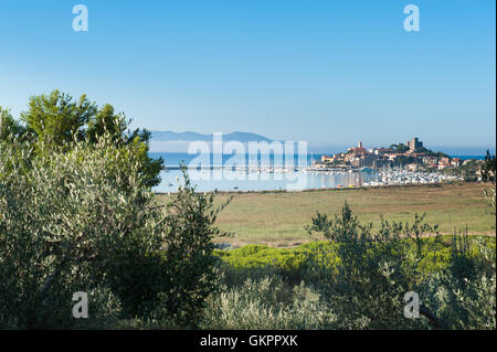 Villaggio Talamone, porto con barche in Toscana, in vista del paesaggio all'alba con cielo blu chiaro Foto Stock