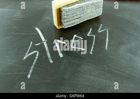 Lo stress scritto in gesso bianco sulla lavagna con gomma. Foto Stock