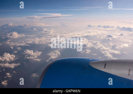 Altocumulus e Cumulus nuvole come visto da un aeroplano finestra con il motore nella foto. Foto Stock