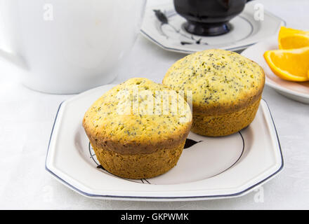 Foto di due orange semi di papavero muffin su piastra bianca Foto Stock
